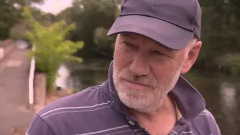 Paul Findlay in a navy and white striped top and a navy cap.