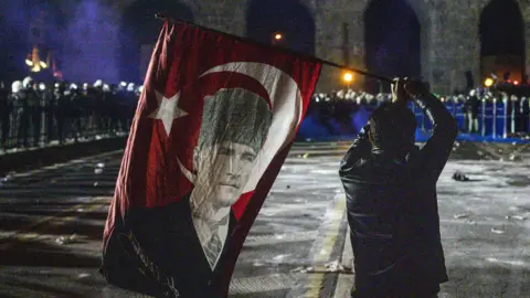 Getty Images A protester waves a flag of Mustafa Kemal Ataturk in front of police in Istanbul