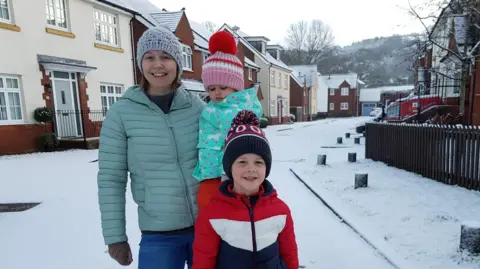 Darren Wheatley Nicola, Oscar and Ffion in the snow. All are wearing padded warm coats and bobble hats. 