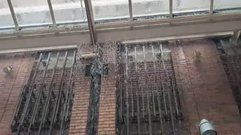 BBC/Ben Maeder A screenshot from a video shows water pouring into The Lanes from skylights.