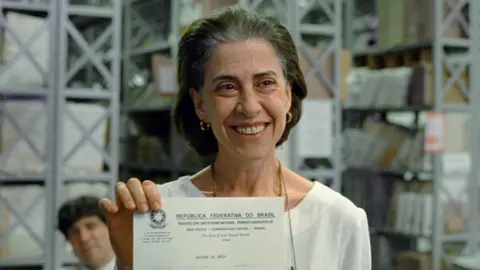 Altitude Films Eunice (played by Fernanda Torres) holds her husband's death certificate