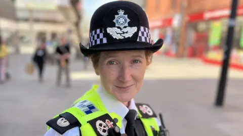 Chief Constable Catherine Roper standing in Swindon town centre wearing a police uniform.