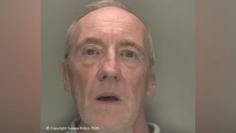 Sussex Police A custody image of a man with short grey hair.