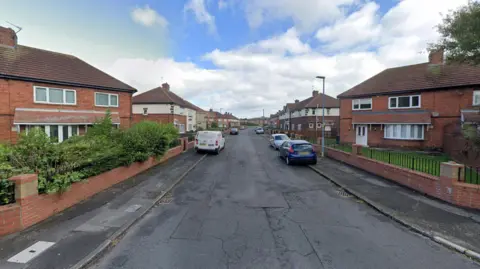 Google Arkley Cresent is a residential street lined with red brick semi-detached houses.