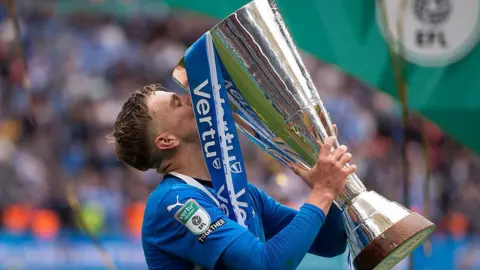 Harley Mills of Peterborough United kisses the trophy after the Vertu EFL Trophy Final match between Birmingham City and Peterborough United at Wembley