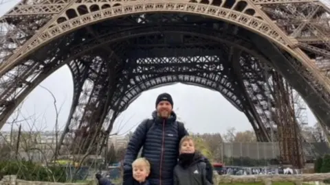 Family handout Damien with this two boys at the Eiffel Tower