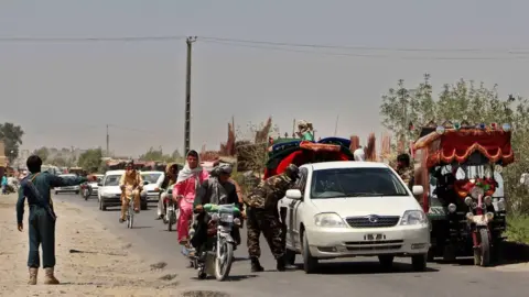 AFP Afghan police search commuters at a checkpoint during a period of fighting in 2016