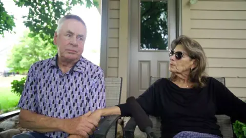 Harry Haluptzok and Linda Haluptzok hold hands. 