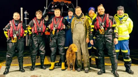 Humber Rescue Buddy the dog stands for a group photo with the team at Humber rescue, after he arrived at the station.  The four crew members are still in their life jackets and wellies.