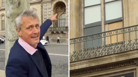 Hugh Schofield points to a broken window at the Louvre museum.