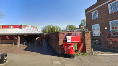 Google Narrow walkway bordered by a Wilko store and a postal sorting office