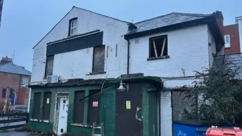 A general view of a former derelict pub building taken on a gloomy day.