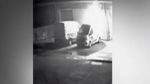 CCTV image of explosion in car, blast happening behind two vans