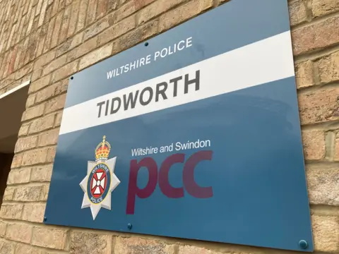 A Wiltshire Police sign on a brick building