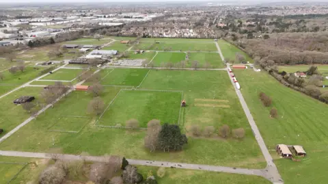 Qays Najm/BBC Aerial shot of Trinity Park, showing its size. There is a lot of green grass, divided by concrete paths and trees. 