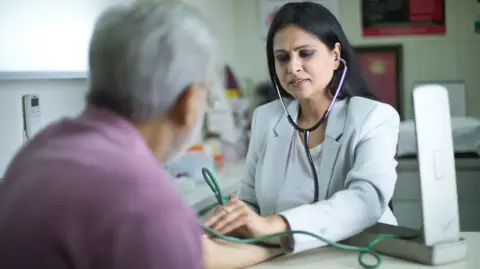 Female doctor taking blood pressure of patient