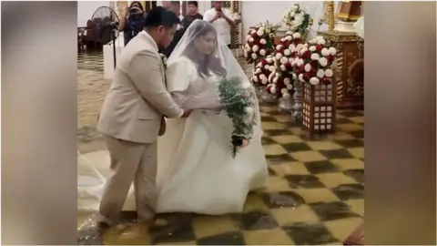 Bride and groom walk down flooded aisle