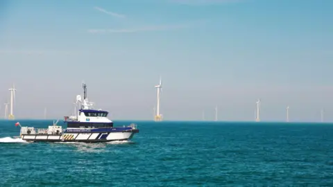 ScottishPower Renewables A wind farm service vessel in the north sea, with turbines in the background