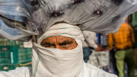 Getty Images Millions work in India as vegetable sellers to earn money