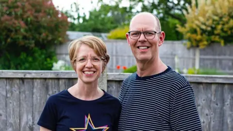 South Yorkshire Police Chris Marriott, who wears a striped t-shirt, stands with his wife Bryony in a garden.