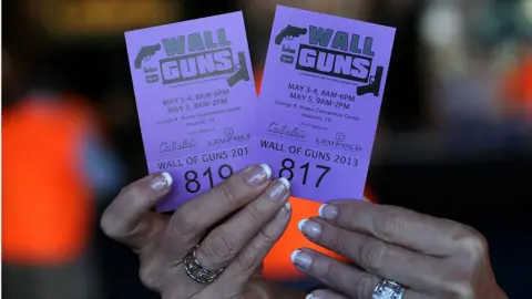 Justin Sullivan A woman tries to sell raffle tickets to win a gun from the 'Wall of Guns' during the 2013 NRA Annual Meeting and Exhibits at the George R. Brown Convention Centre on 4 May 2013 in Houston, Texas.