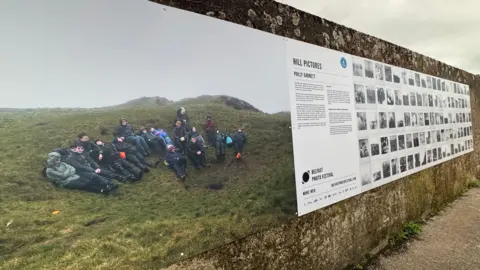 A panel on a wall showcasing an array of photographs
