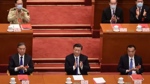 AFP China's President Xi Jinping (c) applauds after the vote during the closing session of the National People's Congress at the Great Hall of the People in Beijing on May 28, 2020