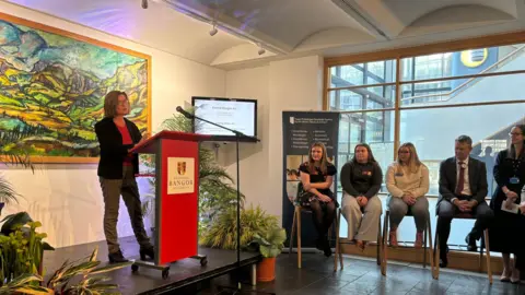 Wales Minister Eluned Morgan speaks from a podium at Bangor University as part of the opening ceremony for the new North Wales Medical School.