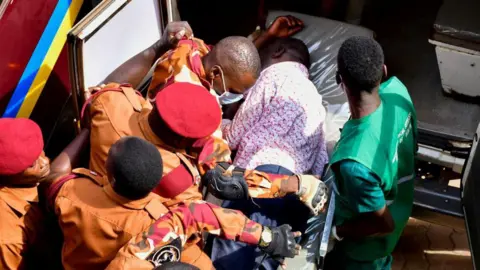Reuters Kizza Besigye is put in an ambulance by uniformed prison guards