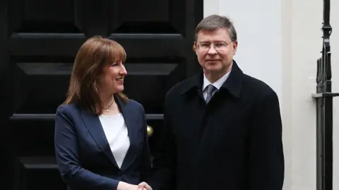 Chancellor Rachel Reeves grins as she shakes hands with European Commissioner for Finance Valdis Dombrovskis outside 11 Downing Street.