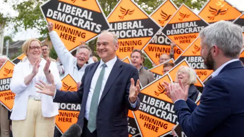 Getty Images Ed Davey standing in front of a group of Liberal Democrat signs.