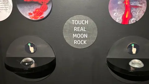 Luke Deal/BBC An exhibition where there are two small stations encouraging people to touch real moon rock. 