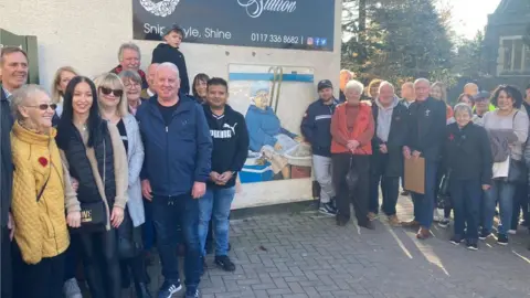 Community gathering around the mural