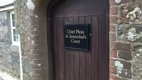 BBC Brown wooden door to Sark town hall