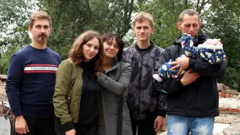 Alla Pylypenko Pylypenko family in front of their destroyed house