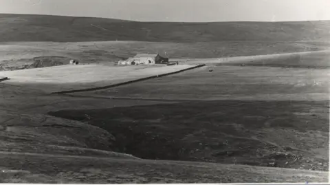 Woodhorn Museum A black-and-white image of a sheep farm set in empty open moorland.
