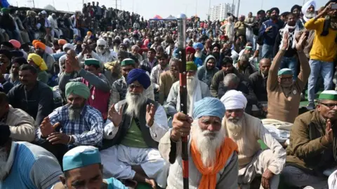 Getty Images Farmers block a highway during a protest against agricultural reforms at the Delhi-Uttar Pradesh state border in Ghazipur on January 30, 2021