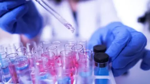 Getty Images syringe over test tubes