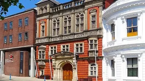 MANX SCENES The exterior of the House of Keys building, which is red brick with an ornately decorated entrance. It sits between the wedding cake building and government offices.