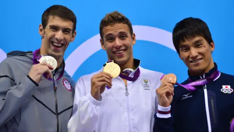 Getty Images Le Clos poses with his gold medal next to Phleps (left) - who retired after the 2016 Rio Games with a record 23 gold, three silver and two bronze medals. Japan's Takeshi Matsuda (right) took bronze.