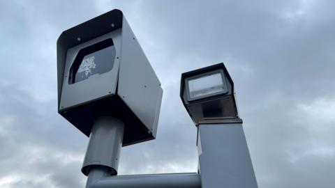 A speed camera with a sticker over the lens