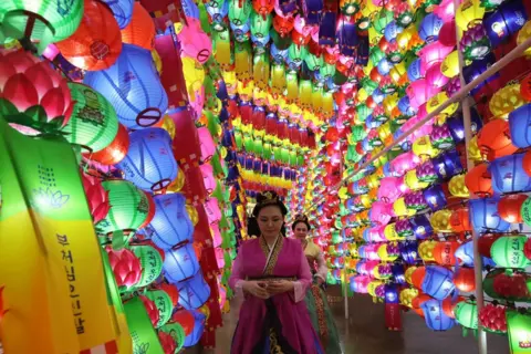 Chung Sung-Jun/Getty Images Buddhists walk under colourful lanterns as they celebrate the Buddha's birthday at Jogyesa temple on May 11, 2024 in Seoul, South Korea.