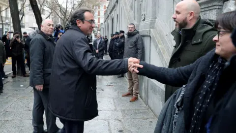 EPA Josep Rull (C) says goodbye to wife Meritxell Lluis before returning to court in Madrid on 23 March 2018