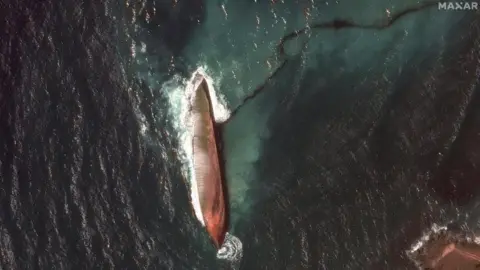 Reuters A satellite image shows a close-up view of a capsized barge and an oil spill, off the shore of Tobago Island, Trinidad and Tobago, February 14, 2024.