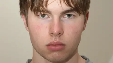 COUNTER TERRORISM POLICING A mugshot of a young man staring at the camera.