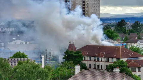 Huge clouds of smoke billow from a block of flats 