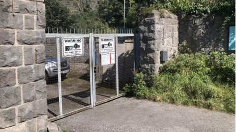 Locked gates with spikes and warning signs