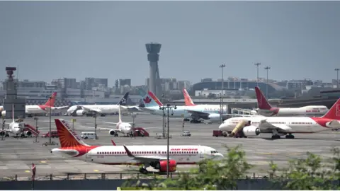 Getty Images Planes are seen parked at Mumbai airport, Many flights has been cancelled during the outbreak of the new Coronavirus, COVID-19.