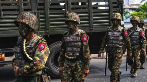 Myanmar military soldiers stand guard after arriving overnight with armoured vehicles on February 15, 2021 near the Central Bank in Yangon, Myanmar.