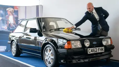 PA Media Silverstone Auctions' classic car specialist Arwel Richards polishes the 1985 Ford Escort RS Turbo